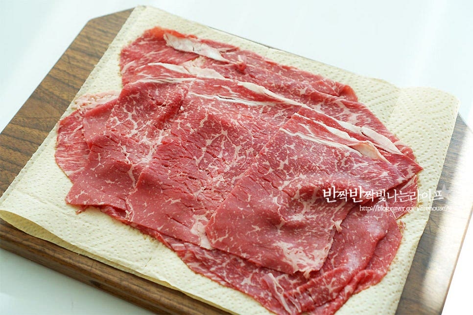 샤브샤브 고기 부위는 얇게 썬 소고기를 준비하는데요. 목심, 앞다리살, 우둔살 등 담백한 부위가 좋아요. 취향에 따라 차돌박이 같은 기름이 많은 부위도 좋지만 먹다 보면 기름이 많이 생겨서 중간중간 걷어가며 드시는 게 좋아요. 정육코너에 가서 샤부샤부용으로 얇게 썰어오시면 됩니다. 야채는 먹기 좋게 잘라줍니다. 너무 크기 써는 것보다 데쳐서 한입에 먹기 좋게 잘라주는 게 좋아요. 알배추는 잎 크기에 따라 4~6등분 하여 준비해요. 청경채는 밑동을 잘라내고 낱장으로 분리하여 줍니다. 큰 잎은 반으로 잘라주어요. 버섯은 밑동을 잘라내고 먹기 좋게 찢어줍니다. 느타리, 표고, 만송이를 준비했는데 송화, 목이, 팽이, 새송이 등 다양하게 준비해 주시면 됩니다. 숙주는 다듬어 준 뒤 씻어 체에 밭쳐 물기를 털어주고, 깻잎은 반으로 잘라 준비해요.