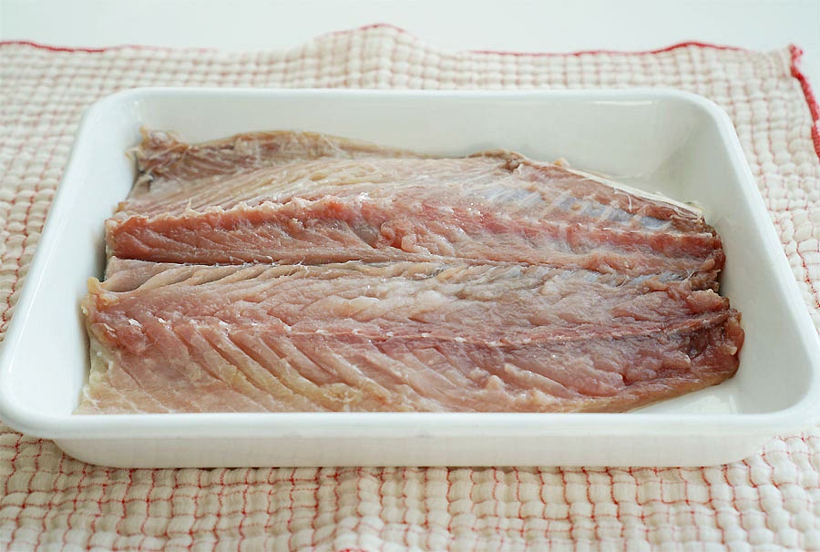 고등어 밑간을 해줍니다. 시장이나 마트에서 구이용으로 구매하면 기본적으로 손질이 되어있기 때문에 크게 손질을 할 것은 없어요. 지느러미는 가위로 잘라 제거해 주고, 먹기 불편한 커다란 뼈도 제거해 줍니다. 넓게 펼쳐 놓은 뒤 맛술 1.5T, 굵은소금 약간으로 30분 정도 밑간을 해줍니다. *간고등어 같은 경우 쌀뜨물에 담가 짠맛을 조금 빼줍니다. 비린내를 잡아주고 싶거나 냉동일 때는 쌀뜨물에 담가줍니다.