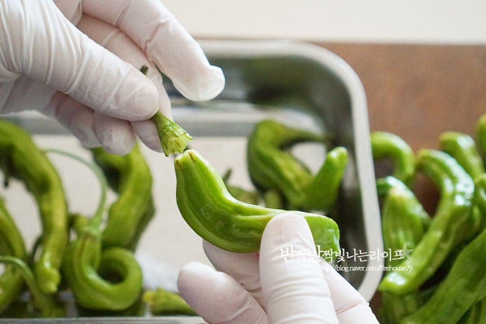 다른 고추와 달리 쭈글쭈글한 모양의 꽈리고추는 제철이라 한창 많이 보이는데요. 은은하게 매운 향이 있어 무침반찬 만들면 여름철 먹기 좋죠. 꼭지를 제거한 뒤 씻어줍니다. 꼭지 부분을 손으로 잡고 당기면 손쉽게 분리가 됩니다. 크기에 따라 너무 큰 것은 반으로 잘라주셔도 좋으며 향이 골고루 퍼질 수 있도록 한두 번 포크로 콕콕 찔러주셔도 좋습니다.