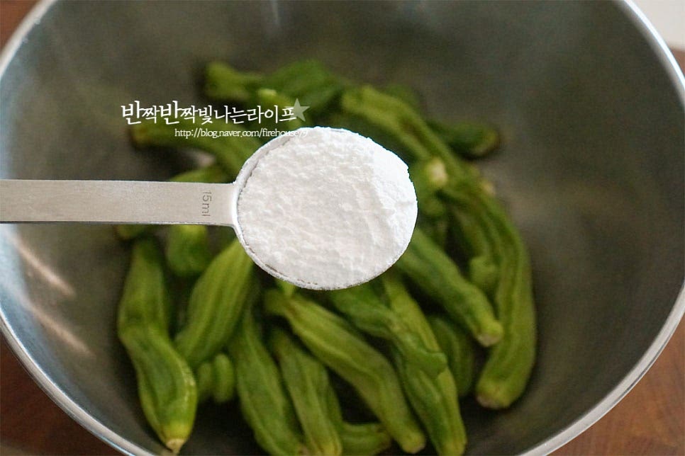 꽈리고추찜무침은 찹쌀가루 또는 밀가루에 버무려 찌는데요. 살짝 흩어가며 뿌려서 골고루 옷이 입혀지도록 해줍니다. 세척 후 물기가 조금 남은 상태에서 버무리면 고르게 찹쌀가루와 어우러집니다. 비닐봉지에 모두 넣고 흔들어도 좋고 저와 같이 큼직한 볼에 넣고 섞어도 좋습니다.