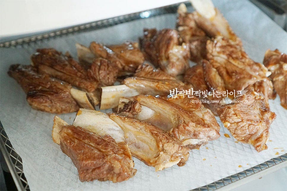 뼈에 붙은 살코기로 팬에 구워서 익히는 것보다 열이 골고루 전달되는 에프를 활용하면 보다 간단하게 요리할 수 있습니다. 트레이에 겹치지 않게 올려줍니다. 에어프라이어 180도 5분씩 총 10분 앞뒤로 뒤집어 구워줍니다. 기기의 사양에 따라 양념소스가 타지 않도록 조절하여가며 조리해 주세요. 5분 익힌 뒤 남은 양념을 모두 발라 다시 한번 5분 구워줍니다. 익힘 정도에 따라 시간은 더해주세요. 지글지글 맛있게 구워지고 있어요. 190도 5분, 180도 10분 총 15분 구워주면 뼈와 살이 분리될 정도로 먹기 좋게 잘 구워진답니다. 먹기좋게 담은 뒤 통깨를 뿌려주면 푸짐하게 완성입니다. 돼지 부위 중에서도 고소한 감칠맛이 진하고 뼈에 붙은 살을 뜯어먹는 식감이 별미인데요. 소금구이로 담백하게 구워도 맛있지만 달콤 짭조름한 맛이라 아이 어른 모두가 먹기 좋아요. 매콤하게 먹고 싶다면 청양고추를 다져 곁들여도 됩니다. 영상도 같이 담았어요. 핏물을 제거한 뒤 향신재료를 넣고 데쳐 잡냄새를 잡아준 뒤 고소한 본연의 맛을 살려 구워 만드는법으로 간단하고 맛깔나게 즐기기 좋답니다. 돼지 쪽갈비구이 단짠 간장 양념과 에어프라이어를 활용한 레시피로 맛있게 요리해드세요. 끄읕 !