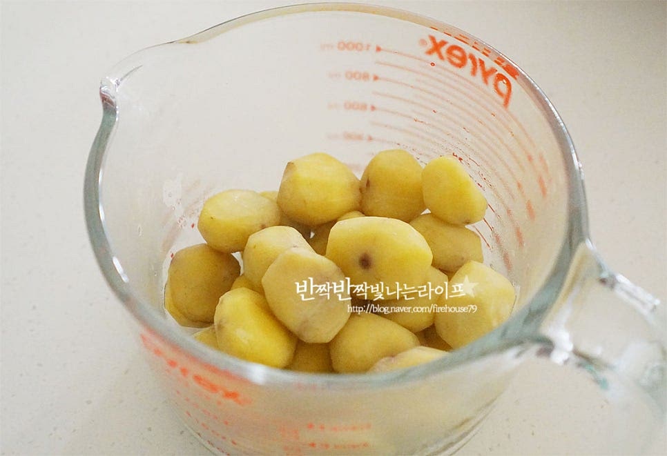 삶은 밤은 입자를 곱게 갈아줍니다. 넉넉한 크기의 볼에 담아주고요. 물 200ml, 우유 100ml를 부어줍니다. 물로만 만들어도 되지만 우유가 들어가면 조금 더 고소함이 진해집니다. 우유는 기본 종류로 넣어주세요. 핸드블렌더로 곱게 갈아줍니다. 물과 우유를 넣어주어서 쉽게 갈아져요. 식감을 조금 더 부드럽게 해주기 위해 체에 한번 내려 냄비에 담아줍니다.
