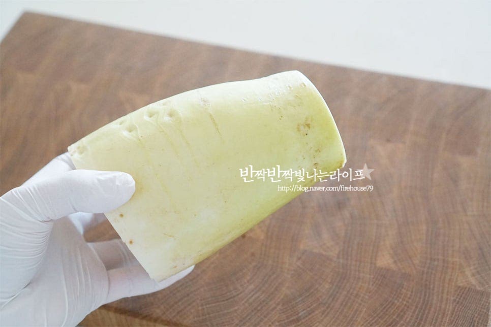 생채를 만드는 무는 초록 부분의 식감이 아삭아삭 더 맛이 좋습니다. 여름에 나는 것은 쓴맛이 나지만 가을 겨울에 수분감이 달큰하니 맛이 좋죠. 요리솔로 살살 문질러 씻어주거나 껍질을 벗겨줍니다. 껍질이 조금 지저분하여 깎아주었습니다. 채를 썰어주기 위해 무를 가로로 세우면 둥글어서 칼질이 서툴다면 어렵게 느껴지는데요. 측면을 약간 잘라준 뒤 세워주면 바닥면이 고정되어 칼로 자르기 훨씬 수월합니다. 일정한 두께로 먼저 잘라줍니다. 어남선생생채 같은 경우 무말랭이 식감과 중간 정도로 오독한 맛을 살리고 싶다면 너무 얇게 썰지 않아도 됩니다. 약간 도톰하거나 얇거나 일정하게 잘라주세요. 곱게 체를 썰어줍니다. 채칼로 썰어 만드는 것보다 칼로 썰어 만들어야 무르지 않고 맛있어요.