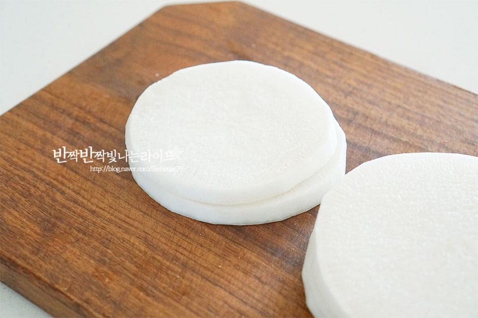 무는 껍질을 벗긴 뒤 0.7cm 두께로 채 썰어줍니다. 절여줄 것이라 너무 얇지 않으면서 두껍지 않게 썰어주는 게 좋아요. 길이가 긴 것은 집어먹기 좋도록 반으로 잘라주고요. 넉넉한 크기의 볼에 담고 천일염 1 큰 술, 물엿 6 큰 술을 넣고 섞어요. 40분~1시간 넉넉하게 절여줍니다. 물엿을 넣고 절이는 과정에서 무의 수분이 나와 식감이 오독오독해지는데요. 꽤 물이 많이 생기고 적당히 수분감이 있으면서 아삭아삭 식감이 맛있어져요. 면포에 넣고 물기를 꼭 짜줍니다. 물기를 꼭 자서 제거해 주어야 물이 생기지 않고 식감도 꼬들꼬들해요. 무김치 절임 정도는 구부려보았을 때 부서지지 않고 휘어지는 정도면 됩니다.