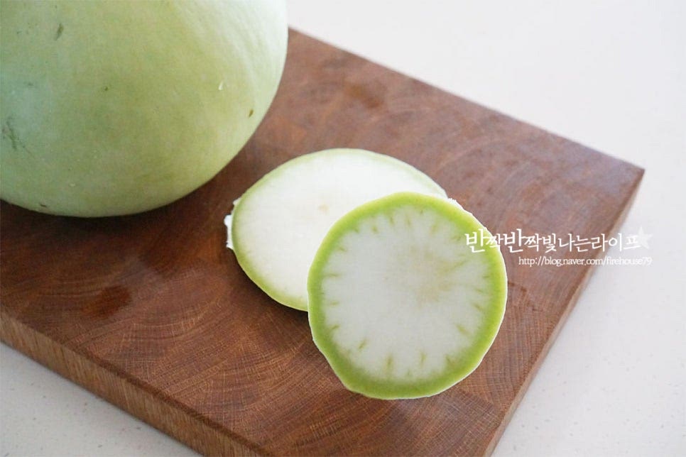 박은 너무 단단하지 않은 연하고 부드러운 것이 요리하기 좋고 쓴맛이 나지 않습니다. 깨끗하게 세척한 뒤 양 끝 부분은 잘라내어 주세요. 반으로 잘라서 1/4통만 박나물을 만들도록 합니다. 남은 박은 손질하여 먹기 좋게 썰어서 냉동실에 소분하여두면 나물이나 국을 끓여먹기 좋습니다. 숟가락을 사용하여 가운데 부분의 씨와 속을 파내어 제거합니다. 속을 긁어서 손질한 뒤 껍질을 깎아줍니다. 감자칼로 긁어도 좋고 칼로 깎아주셔도 됩니다. 껍질 부분을 만져보면 보드라운 박은 질기지 않고 부드러우면 여물어 쓴맛이 나는 것은 단단합니다. 얄팍한 두께로 편으로 썰어줍니다. 너무 두꺼워도 조리시간이 길고 식감이 별로라 적당하게 얇게 썰어주면 하나씩 집어먹기 좋습니다. 한입 먹어보면 은은한 단맛이 나는 게 박나물볶음 만들기 딱 좋았는데 쓴맛이 나는 것은 소금이나 설탕에 절여서 만들어주는 게 좋습니다.