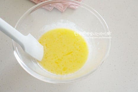 버터와 우유를 녹여서 섞어둔 볼에 반죽을 한 주걱 덜어서 넣어줍니다. 이때 녹은 버터와 우유의 온도는 50~60도 정도로 따뜻한 상태입니다. 부드럽게 섞어줍니다. 섞은 반죽을 합쳐서 섞어줍니다. 이때 거품이 꺼지지 않게 아래에서 위로 주걱을 움직여 섞어줍니다.