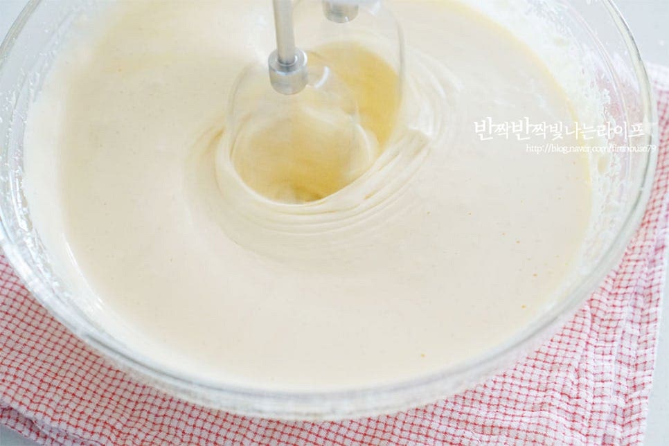따뜻한 상태의 계란물을 핸드믹서로 휘핑해줍니다. 40도 정도의 따뜻하게 온도를 올려 풍성하면서도 조밀하게 거품을 올려주어야 부드러운 카스테라머핀을 만들 수 있어요. 풍성한 아이보리색의 거품을 만들어줍니다. 거품기를 들어보았을 때 몇 초 동안 자국이 남는 정도면 됩니다. 박력분 80g, 베이킹파우더 2g을 곱게 체에 내려줍니다. 아래에서 위로 거품이 꺼지지 않고 날가루가 보이지 않게 섞어줍니다.
