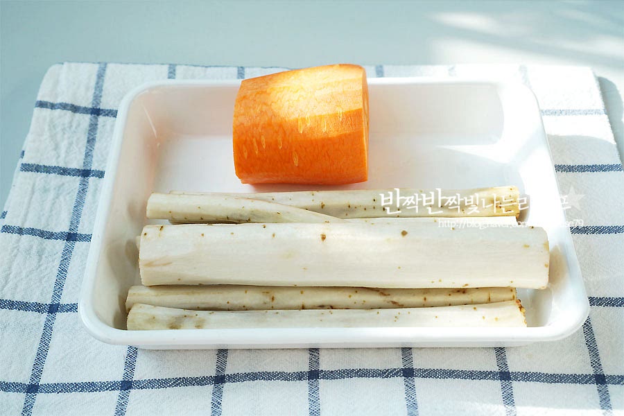 야채를 채썰어주세요. 우엉과 당근 모두 필러로 껍질을 벗겨준 뒤 먹기 좋게 썰어줍니다. 우엉은 껍질째 먹음 영양소가 더 많아 칼등으로 살짝 긁어내어 손질해도 되지만 저는 깔끔하게 먹고 싶어서 필러로 껍질을 벗겨주었어요. 우엉 채썰기는 어슷하게 슬라이스한 뒤 채를 썰어주면 먹기 좋은 길이로 자를 수 있어요. 당근이 함께 들어가면 색감도 먹음직스럽고 당근에서 나오는 단맛이 어우러져 더 맛있는 조림을 만들 수 있어요. 당근 역시 채 썰어 준비해 줍니다.