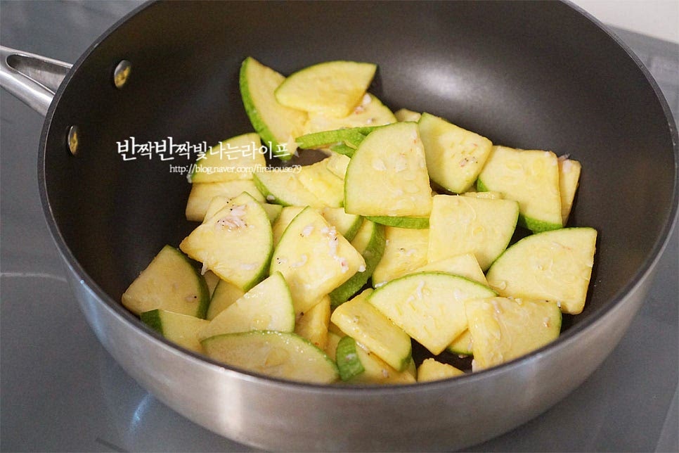 깊이가 있는 팬이나 냄비에 절인 호박을 넣어줍니다. 들기름 2 큰 술, 간 마늘 1/2 큰 술 참치액 1 작은 술, 다진 파를 함께 넣어줍니다. 들기름으로 볶으면 구수합니다. 불을 켜고 전체적으로 골고루 어우러지도록 볶아줍니다. 볶다 보면 수분이 나오면서 촉촉해집니다. 2~3분 정도 볶다가 양파도 넣어줍니다. 호박과 양파가 어우러지면 육수 또는 물 80ml를 부어줍니다. 수분의 양은 화력에 따라 농도를 조절해 줍니다. 물을 넣어도 되지만 육수를 조금 넣으면 나물볶음의 감칠맛이 더 좋습니다. 뚜껑을 덮고 중불로 3분 정도 익힙니다. 국물이 적당하게 자작하면서 부드럽게 잘 익었어요. 부족한 간은 소금이나 새우젓으로 맞추고 홍고추와 통깨를 넣고 마무리합니다. 구수하게 먹고 싶다면 들깨가루를, 매콤하게 먹고 싶다면 고춧가루를 약간 넣어도 좋습니다.