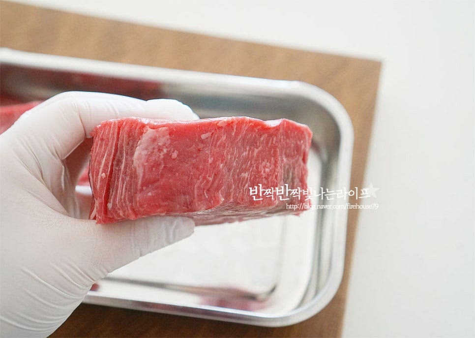 부드럽고 연하여 아이어른이 함께 먹기좋은 안심을 준비했습니다. 재료 본연의 풍미와 육즙을 풍부하게 살려 맛있게 굽는법이 중요한데요. 한 덩이에 250g 정도이며 두께 3~4cm의 스테이크용 소고기입니다. 두께에 따라 굽는 시간과 익힘 정도가 다를 수 있으니 참고하시어 조절해 주면 됩니다. 키친타월로 겉의 핏물을 가볍게 제거해 줍니다. 시즈닝 기본 양념재료는 소금, 후추로 입맛에 맞게 갈릭 솔트와 같은 시판용 소금을 활용해 주면 됩니다. 양면에 소금, 후추를 갈아 뿌려줍니다. 두께에 따라 넉넉하게 뿌려주셔도 좋아요. 올리브오일 2 큰 술을 겉에 골고루 발라줍니다. 시즈닝 하면서 모양을 동그랗게 도톰하게 잡아줍니다. 전처리 과정에서도 모양을 내어주면 구웠을 때 수축되는 과정에서도 두툼하고 맛있게게 구워져요. 로즈마리와 같은 허브 종류를 곁들여도 좋아요. 요즘엔 실온에 그대로 15분 정도 둡니다. 간이 스며들고 실온에서 냉기가 빠질 수 있도록 해주는데요. 냉장고에서 바로 꺼내어 굽는 것보다 차가운 냉기를 빼주게 되면 구울 때 열이 골고루 전달되어 속까지 굽기 조절을 하기 좋습니다. 차가운 상태로 구울 때는 익힘시간이 조금 차이 날 수 있어요.