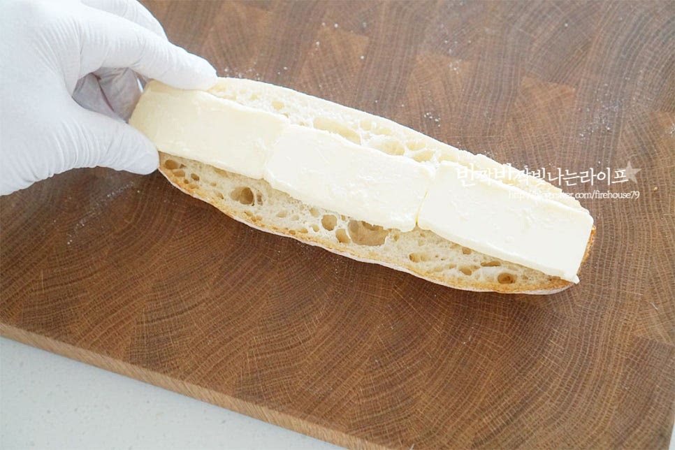 반으로 자른 단면 한쪽 면에 버터를 올려줍니다. 조각으로 올려주셔도 좋고 부드럽게 발라주셔도 좋아요. 그 위로 잠봉을 겹겹이 올려줍니다. 얇은 햄을 쌓아 올려주면 보기에도 푸짐해 보이고 쫄깃한 식감도 맛볼 수 있어요. 버터를 바른 나머지 바게트를 덮어줍니다.