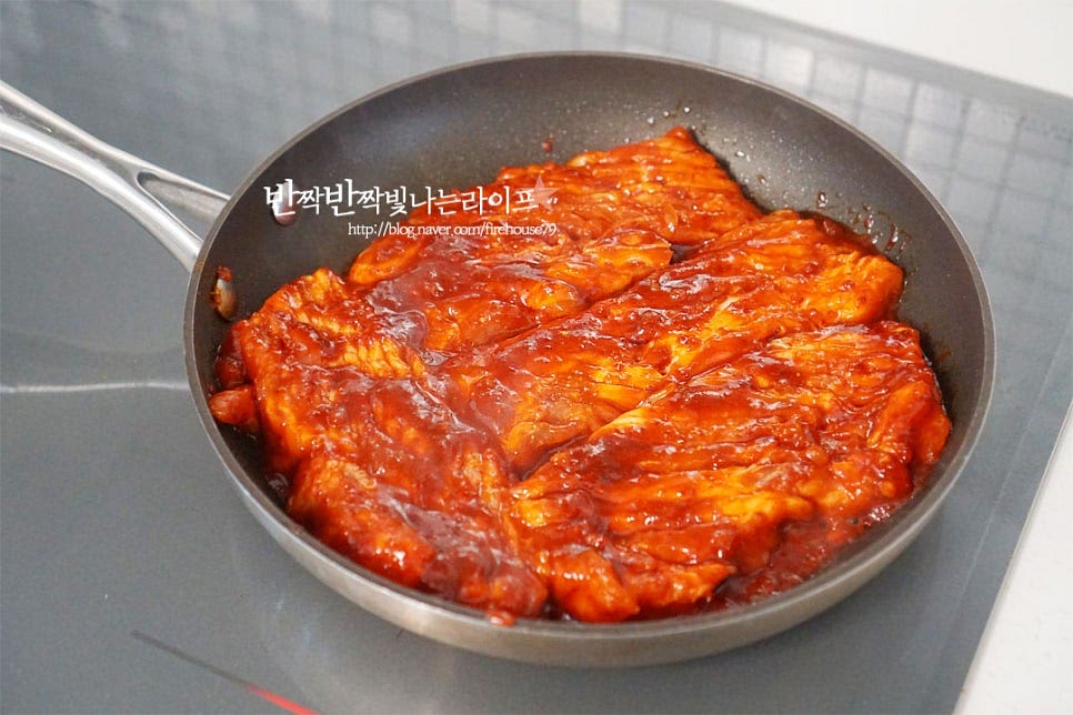달군 팬에 재운 고추장삼겹살을 올려줍니다. 기름이 많은 부위라 익으면서 기름이 나오지만 팬의 코팅력에 따라 식용유를 조금 발라주셔도 좋습니다. 양념고기라서 타기 쉬우니 앞뒤로 겉면이 익으면 중약불로 낮추어 눌어붙거나 타지 않게 뒤집어가며 구워주세요. 남은 양념을 발라가며 촉촉하게 구워줍니다. 고소한 기름이 나오면서 풍미도 깊어집니다. 절반 이상 익으면 한 입 크기로 먹기 좋게 잘라줍니다. 자른 뒤 양념에 버무려 구워주면 됩니다.