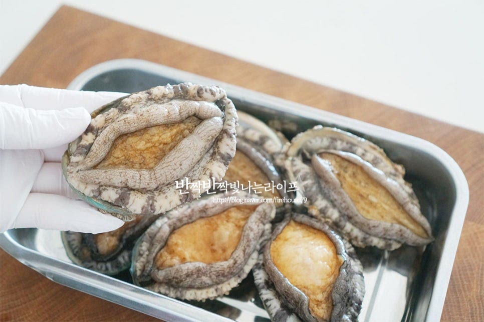 크기에 따라 준비해주면 되는데요. 저는 6미 준비해서 3마리는 통으로 올리고 3마리는 편으로 썰어 식감을 살려주었습니다. 조리용 솔로 문질러 세척해 줍니다. 이때 너무 세게 문지르면 살이 부서질 수 있으니 조심해 주세요. 껍질의 동그란 홈이 있는 부분으로 숟가락을 넣어 살을 분리한 뒤 내장을 분리해 줍니다. 이빨까지 제거해 깔끔하게 손질해요. 내장은 모래주머니를 잘라내고 핸드블렌더로 곱게 갈아줍니다. 가위나 칼로 잘게 다져 썰어도 되지만 갈아서 넣으면 쌀알과 더 잘 어우러져 구수한 맛을 냅니다. 반은 한입에 먹기 좋게 편으로 썰고 나머지 반은 격자로 칼집을 넣어 익었을 때 먹음직스럽게 해줍니다.