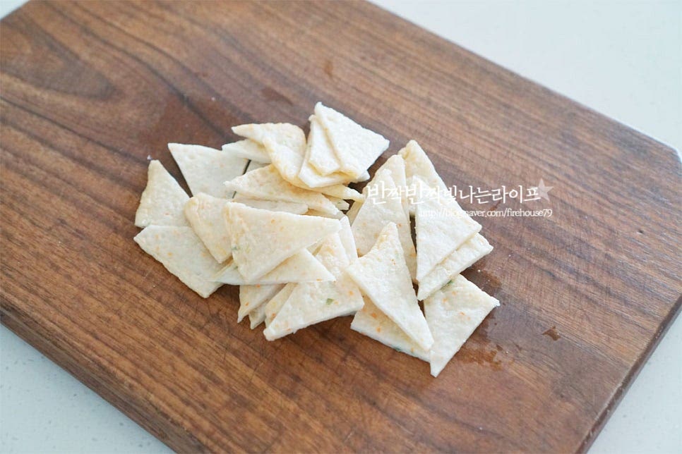 충무김밥에 깊은 맛 더해주는 오징어무침엔 어묵이 같이 들어가는데요. 얇은 두께의 사각어묵으로 만들면 양념이 잘 스며들어 더 맛이 좋습니다. 집어먹기 좋은 크기로 잘라주는데 세모 또는 네모나게 썰어주세요. 오징어는 내장과 눈, 입을 제거하여 손질한 뒤 반으로 잘라 칼집을 넣어줍니다. 파채칼을 사용하면 간단한데요. 칼집은 생략 가능하지만 넣어주면 간이 잘 배요. 몸통은 1~1.2cm로 채 썰어주고, 다리 부분도 길이를 맞추어 잘라줍니다. 재료 손질이 끝나면 데쳐서 익혀주는데요. 끓는 물에 먼저 어묵을 넣고 살짝만 데쳐줍니다. 오래 익히면 퍼져서 불순물이 제거되고 데워질 정도로만 가볍게 데쳐주었어요. 끓는 물에 오징어와 생강술(청주) 1/2 큰 술 넣고 1분 정도 데쳐서 익혀줍니다. 오징어도 오래 데치면 질겨질 수 있어 탱글탱글하게 익혀주었습니다. 물기를 털어낸 재료를 볼에 담고 양념재료를 넣어줍니다. 고춧가루 2 큰 술, 액젓 2½~3 큰 술 간 마늘 1 큰 술, 진간장 1 큰 술 황설탕 1½ 큰 술, 물엿 2 큰 술 다진파 1 큰 술, 참기름 1 큰 술 통깨 약간 넣어줍니다. 간을 보고 입맛에 맞게 조절하여 맛깔나게 버무려줍니다.