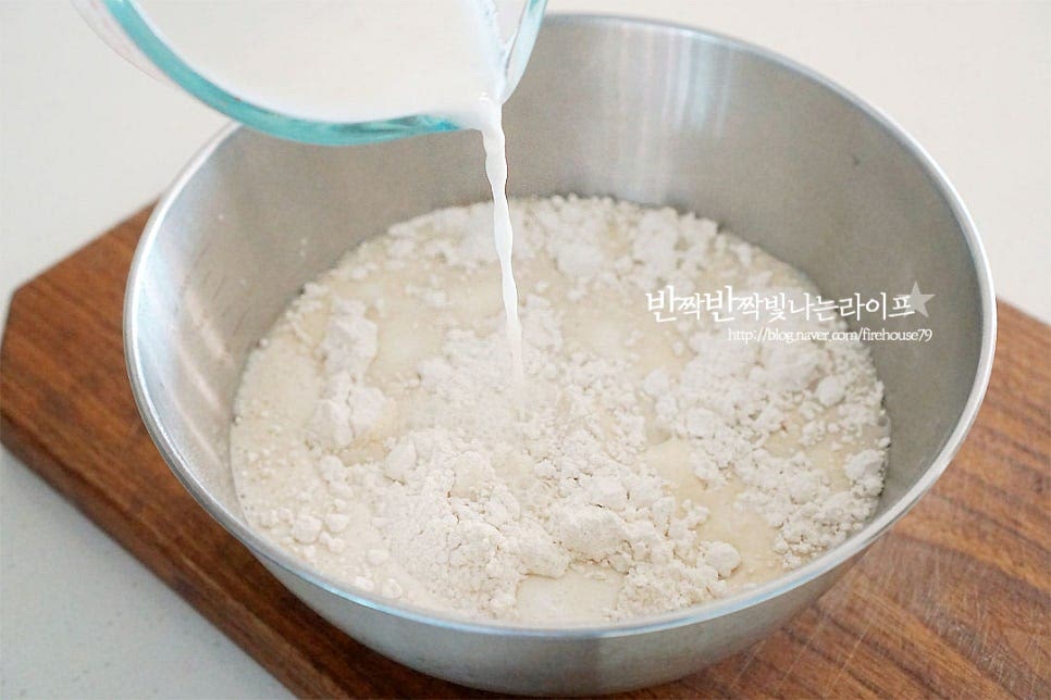 가루가 담긴 볼에 섞은 우유물을 넣어요. 막걸리를 먼저 넣어줍니다. 생막걸리라고 적인 걸 넣으셔야 반죽이 발효가 됩니다. 저는 지평*생막걸리 넣어서 만들었어요. 냉장고에서 미리 꺼내두어 냉기를 빼준 뒤 넣었어요. 가루에 따라 수분의 양이 다를 수 있어 한 번에 다 넣지 않고 넣어가며 농도를 맞추어주세요. 저는 건식 가루라 수분을 조금 더 넉넉히 넣어주었어요. 날가루가 보이지 않게 잘 섞어줍니다. 반죽 농도는 묽은 듯 걸쭉한 정도입니다.