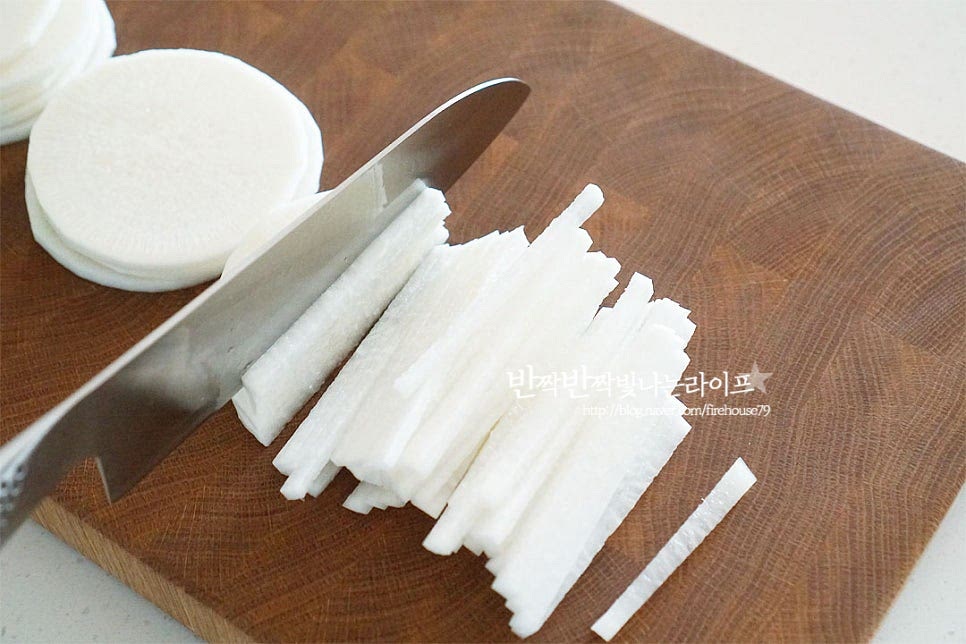 단맛이 나고 수분이 많은 초록 부분이 생채무침을 만들기 맛있어요. 설탕에 절여 만드는 것이라 꼭 초록부분이 아니더라고 괜찮습니다. 1.5kg 정도 크기의 무 1/3개 500g을 준비한 뒤 일정한 두께로 채 썰어줍니다. 껍질째 만들어도 되지만 여름엔 껍질이 질겨서 깎아낸 뒤 편 썰기 하고 2~3mm 정도 두께로 채 썰어줍니다. 칼질이 서툴다면 측면을 평평하게 자른 뒤 바닥면을 고정하여 잘라주면 수월해요. 일정한 크기로 잘라야 간이 알맞게 어우러지고 채칼을 사용하는 것보다는 직접 칼로 썰어야 무르지 않게 만들 수 있어요. 무말랭이 식감의 중간 정도로 너무 얇거나 두껍지 않아야 수분이 빠져도 오독오독 합니다.