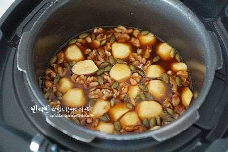 재료가 담긴 솥을 넣고 일반 백미 취사 버튼을 누르고 밥을 짓습니다. 대략 30~40분이 걸립니다. 알토란 약밥 만들기 정말 간단하죠. 취사 후 뚜껑을 열어보니 색이 곱게 만들어졌어요. 전기 압력밥솥이 재료를 모두 넣고 약식 만들기 하면 간단해요. 넉넉한 크기의 볼에 담아 펼쳐 한 김 식혀줍니다. 식혀야 쫀득한 찰기가 맛있습니다. 건포도 60g, 참기름 2 큰 술, 계핏가루 1/2 큰 술을 넣고 골고루 섞어줍니다. 입맛에 따라 건포도와 계핏가루는 조절해 주세요. 섞은 재료를 다시 밥솥에 넣고 보온 재가열 버튼을 눌러줍니다. 대략 10~15분 정도 재가열하면 약밥의 쫀득함을 살리고 전통방식의 맛을 낼 수 있습니다. 깊이가 낮은 용기에 참기름을 골고루 바르고 약밥을 넣고 식힙니다. 꾹 누르면 재료가 부서질 수 있으니 살짝 모양을 잡아주고 참기름을 바르면 고소한 풍미는 물론 분리가 쉽고 윤기가 납니다. 대추말이와 잣을 입맛에 맞게 올린 뒤 틀에서 분리한 뒤 먹기 좋게 잘라 전기밥솥 약밥 만들기 완성합니다.