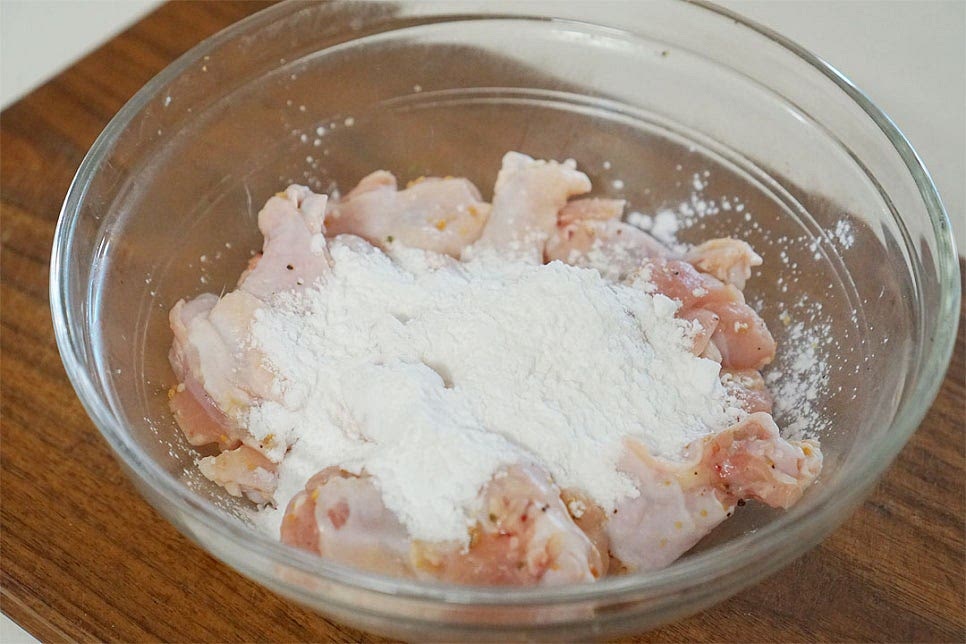 10분 뒤 간이 스며들면 전분가루 4큰술 넉넉하게 넣고 버무려줍니다. 전분 옷을 입혀 구워주면 겉의 바삭한 식감과 소스가 더 잘 스며들어 간이 잘 배요. 고르게 옷이 입혀지도록 버무려줍니다. 닭에 남아있는 수분과 가루가 어우러지도록 해주면 옷이 겉돌지 않고 내내 바삭해요.