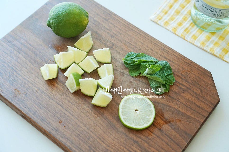 라임은 1/2개를 잘라 데코를 해줄 슬라이스 한 조각과 나머지는 적당한 크기로 잘라줍니다. 볼 이나 절구에 라임과 민트를 넣어요. 단맛을 내어줄 설탕 2 작은 술 넣어줍니다. 설탕량은 취향껏 가감하여 주세요. 찧어서 즙과 향을 내어줍니다. 민트는 너무 많이 찧으면 특유의 향긋함 보다 풀 내음의 쓴맛이 날 수 있으니 재료의 즙과 향을 내어줄 정도의 머들링을 해줍니다.