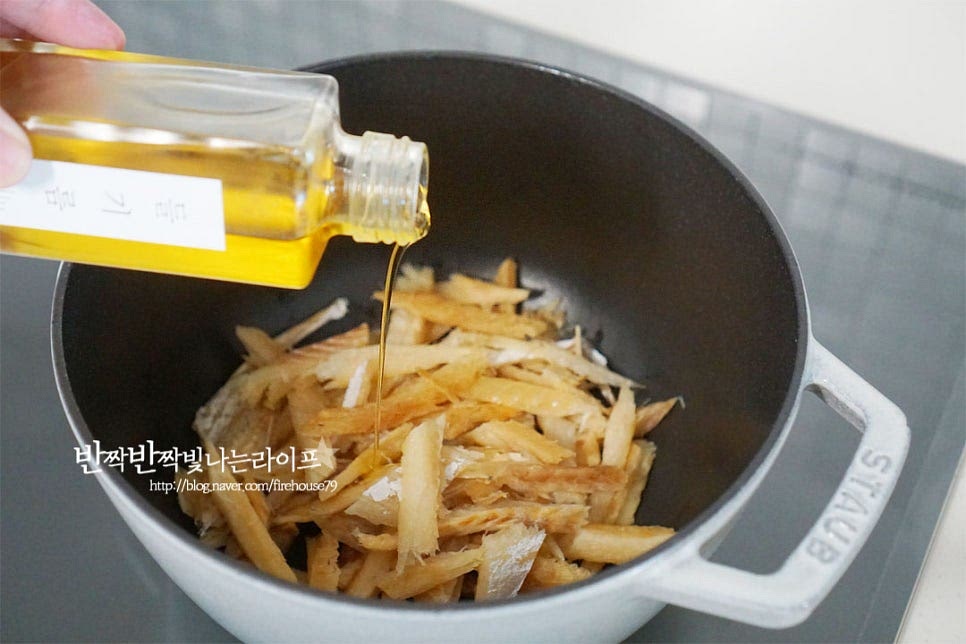 촉촉하게 손질해둔 황태채에 들기름 1½ 큰 술을 뿌려 조물조물 버무려줍니다. 불을 켜고 볶아줍니다. 1~2분 정도 가볍게 볶다가 무를 함께 넣고 볶아주세요.