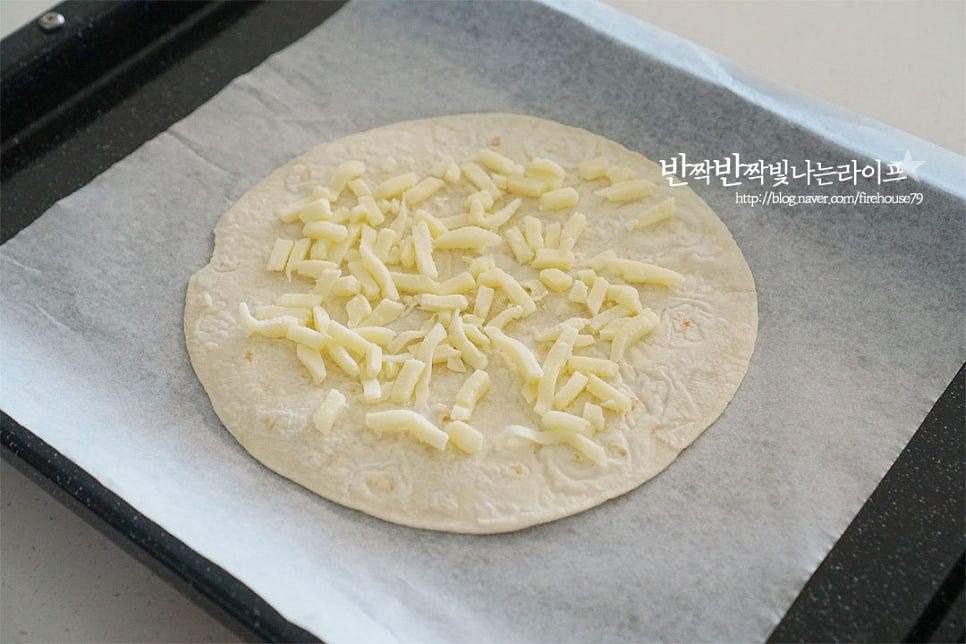 토르티야 한 장을 먼저 깔고 그 위로 피자치즈 1/4 정도 올려줍니다. 그리고 나머지 한 장을 올려줍니다. 도우 반죽에 비해 얇은 편이라 치즈를 사이에 넣고 두 장을 겹쳐 만들어주었어요. 기호에 따라서 한 장으로 만들어주셔도 좋아요. 소스를 얇게 발라줍니다. 진하기 농도에 따라 양은 조절해 주세요. 토마토 함량이 높은 것이 새콤한 맛이 고소하고 담백하게 잘 어울린답니다. 그 위로 남은 피자치즈를 넓게 올려줍니다. 토마토와 치즈를 번갈아가며 올려줍니다.