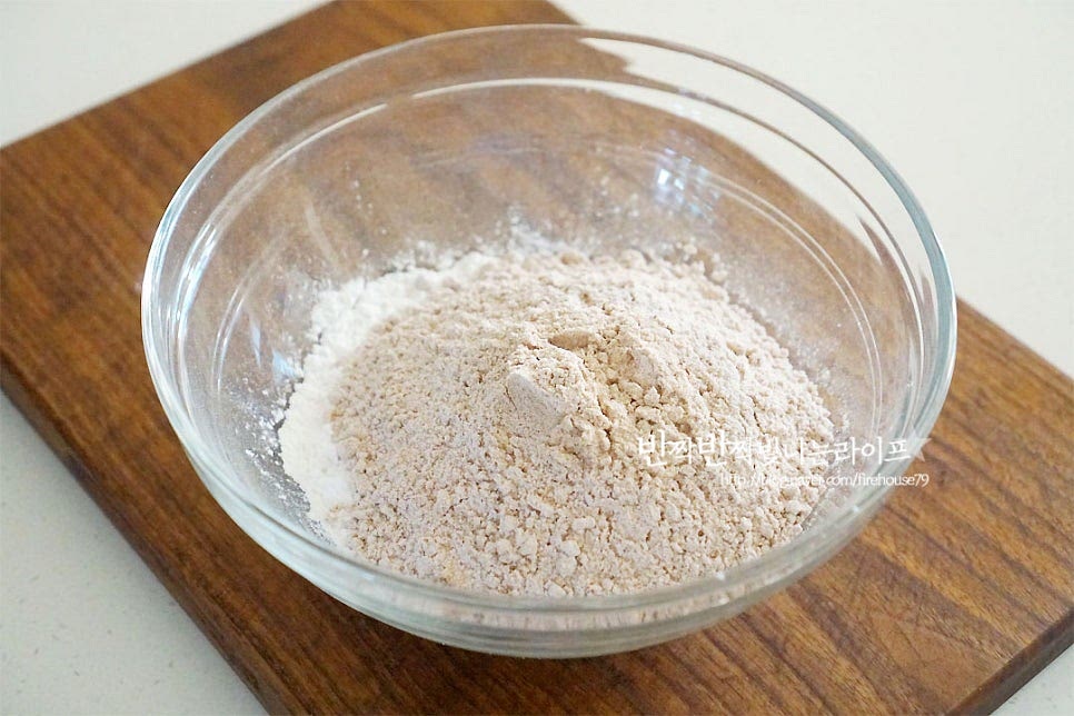 수수가루와 찹쌀가루를 1:1 비율로 넣어 반죽을 만들었어요. 기호에 따라 수수나 찹쌀의 양을 조절해 주세요. 수수가 많이 들어가면 구수한 향이 더 깊고 찹쌀이 많이 들어가면 더 찰진 식감이에요. 수수떡 반죽은 익반죽입니다. 뜨거운 물을 부어가며 반죽을 해줍니다. 처음부터 물을 넉넉히 붓기보다 조금씩 넣어가며 반죽을 뭉쳐가며 물을 또 추가하여 반죽해 줍니다. 덩어리가 점점 커지면서 한 덩어리로 뭉쳐져요. 칠기가 돌게 부지런히 치대어 주었어요. 반죽은 비닐에 넣어 30분 정도 둡니다.