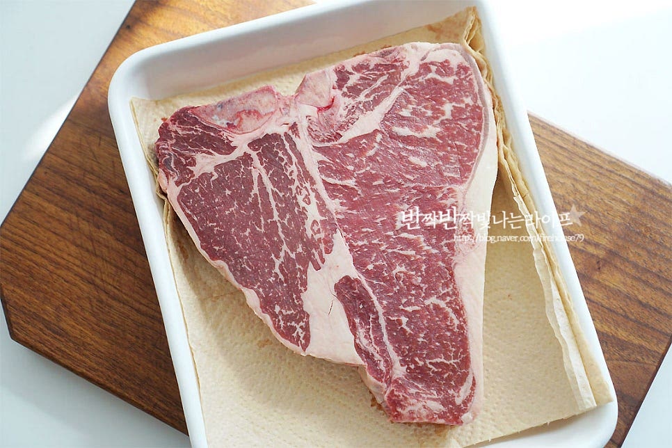 T 뼈를 중심으로 안심과 채끝이 있는 부위로 두 가지 매력을 모두 맛볼 수 있어요. 저는 냉동고기라서 냉장실에서 해동한 뒤 냉기를 빼주기 위해 미리 실온에 20분 정도 두었어요. 차가운 상태로 바로 굽게 되면 열이 골고루 전달되지 않기 때문에 미리 꺼내어 냉기를 빼주는 것에서부터 시작입니다. 키친타월로 핏물을 꼼꼼하게 제거해 줍니다. 소금, 후추를 뿌려 밑간해주는데요. 요즘은 집이나 캠핑에서 소고기를 구워 먹기 좋도록 시즈닝 솔트가 다양해 그걸 활용해도 좋아요. 저는 갈릭 솔트를 뿌려주었어요^^ 소금 간을 살살 두드려준 뒤 올리브오일을 전체적으로 발라줍니다. 시즈닝 하여 5~10분 정도 둡니다.