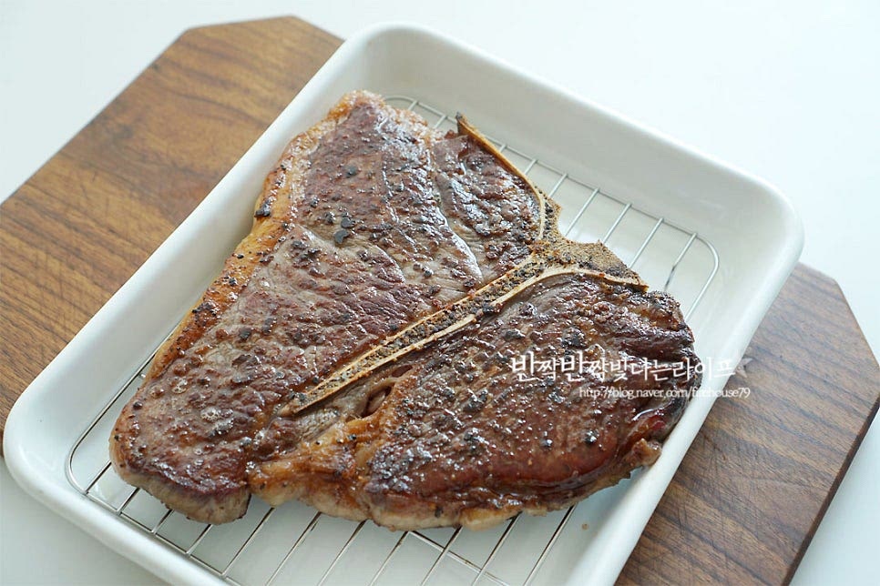 스테이크를 구웠다고 끝이 아니죠. 다음으로 중요한 레스팅 과정이 남았어요. 먼저 채반이 있는 그릇에 노릇하게 구운 고기를 올려요. 그리고 종이 포일을 덮어 5분 정도 두면 육즙이 골고루 퍼져 더 맛있게 드실 수 있답니다. 체위에 올려 공기가 통하도록 레스팅을 하여줍니다.