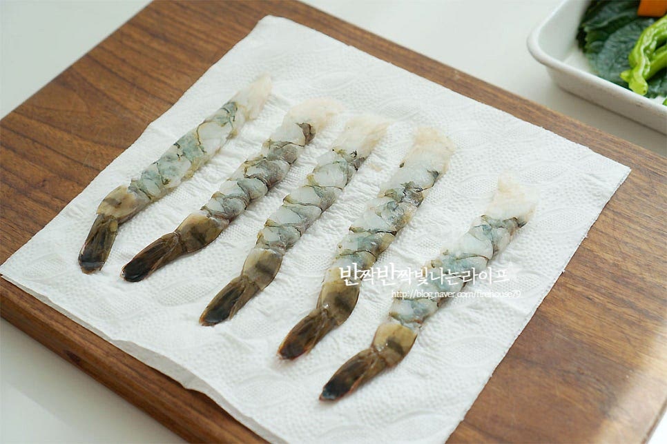 새우는 내장과 껍질을 손질한 뒤 키친타월로 물기를 제거해 줍니다. 저는 손질된 새우라 일자로 모양을 잡아줄 필요가 없었는데 새우 살 안쪽 면에 칼집을 넣어 일자로 모양을 잡아주면 보다 먹음직스럽게 튀길 수 있어요. 연근은 5mm 정도로 얇게 슬라이스하고 단호박 역시 얇게 슬라이스해요. 꽈리고추는 꼭지를 제거해 주고, 깻잎과 버섯도 같이 준비해요. 버섯은 밑동을 분리하고 칼집을 넣어 모양을 내어주었어요. 채소마다 각각의 매력이 있지만 꽈리고추와 깻잎을 튀겨내면 재료의 향긋함이 고소함과 잘 어우러져 꼭 같이 곁들여 드셔보세요~ 김은 먹기 좋게 잘라줍니다. 손질한 재료들은 튀김가루 옷을 얇게 묻혀줍니다.