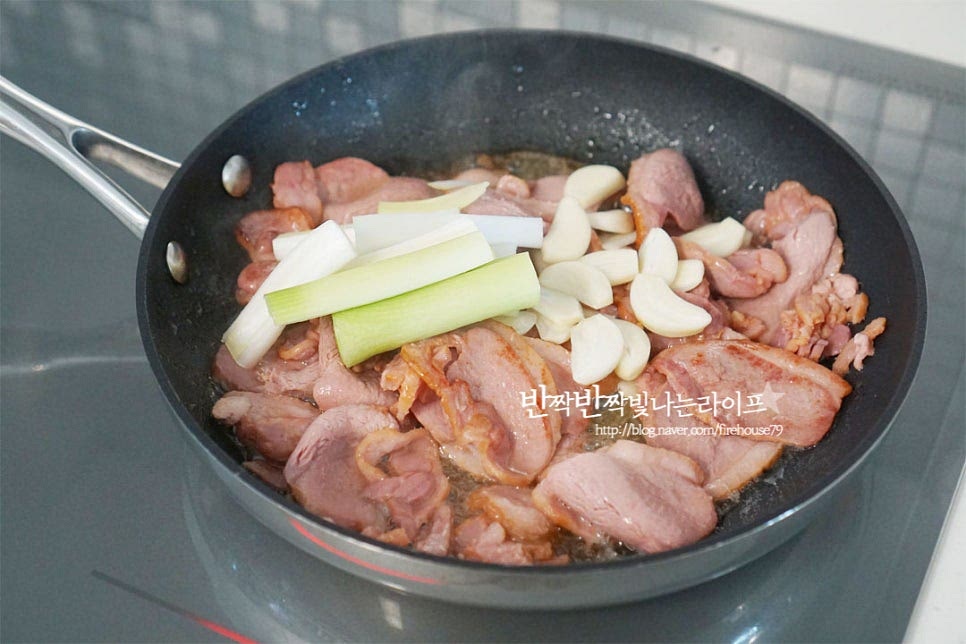 익으면서 노릇해지고 기름이 나옵니다. 그럼 향신 재료인 마늘과 대파를 넣어줍니다. 양파, 파프리카도 함께 넣어줍니다. 야채의 식감이 아삭할 수 있게 어우러지도록 중간 센 불에서 볶아주세요. 재료가 어우러질 수 있도록 볶아줍니다.