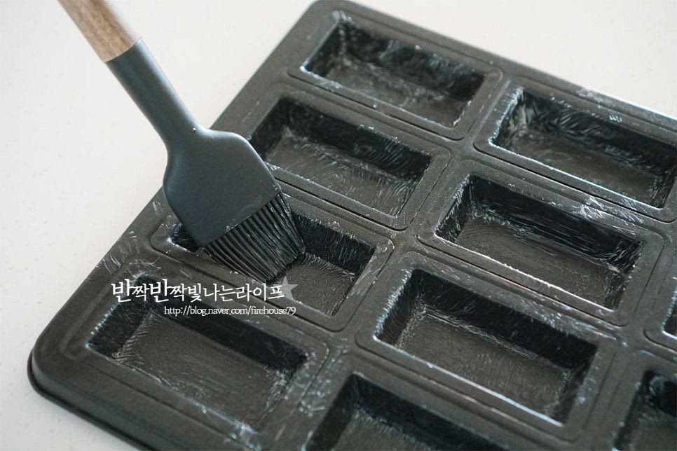 휘낭시에 틀에 부드러운 상태의 버터를 고르게 발라줍니다. 한 시간 휴지 한 반죽을 꺼내어 가볍게 섞어준 뒤 짤 주머니에 담아줍니다. 반죽이 안정화되면서 조금 더 쫀쫀해집니다. 전처리해둔 틀에 80% 정도 팬닝해줍니다. 기본 플레인 반죽에 발로나 초코 스틱을 더했어요. 반은 플레인, 반은 초콜릿을 올렸습니다. 팬닝하고 토핑해주었습니다. 190도 예열한 오븐에 넣고 190도 14~16분 구워줍니다. 기기의 사양에 따라 온도와 시간은 조절해 주세요. 구움색이 나며 배꼽이 터지게 구워지면 틀에서 분리하여 식힘망에 올려 식혀줍니다.