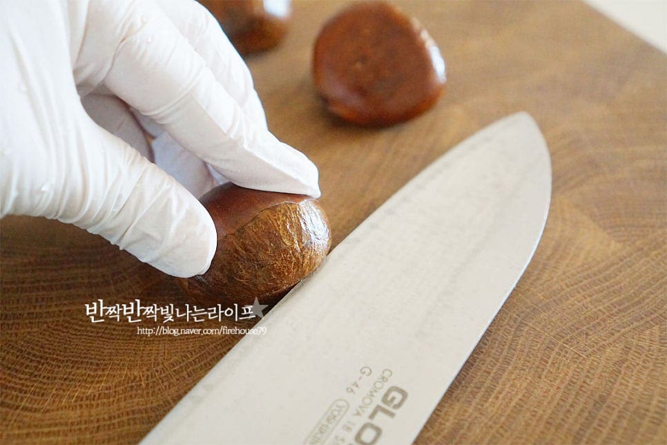 물에 담가 씻었기 때문에 껍질 부분이 조금 부드러워진 느낌이 드는데요. 이제 칼집을 넣어줍니다. 단단하여 손을 다치기 쉬우니 조심해 주세요. 칼집내는 방법은 일자 또는 열십자로 낼 수 있는데 저는 아랫부분에 일자로 길게 넣어주었습니다. 너무 얕게 해도 터지지 않고, 너무 깊게 넣어도 반으로 잘라지면서 익으니 속껍질까지 알맞게 칼집을 내어주는 게 포인트입니다. 색이 다른 연결 부분까지 길게 넣어주었어요. 단단하고 매끈하기 때문에 바닥면에 놓고 눌러준 뒤 칼을 움직여 칼로 길게 내었는데 편한 대로 가위를 활용해도 좋습니다.