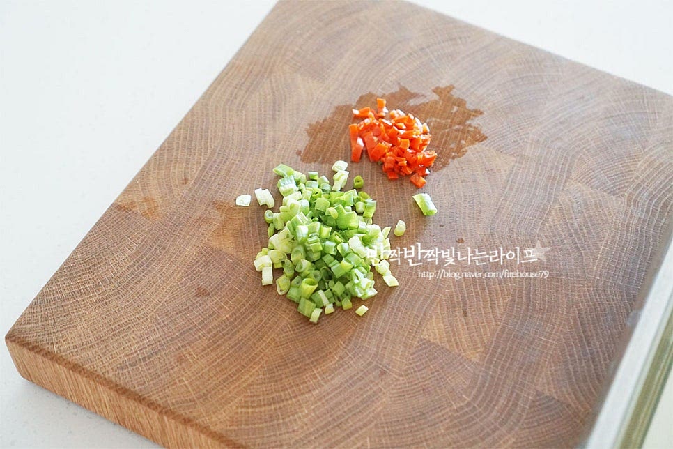 맛과 색감을 더해주는 야채를 달걀물에 넣어줄 것이에요. 쪽파는 잘게 송송 썰고, 홍고추는 가운데 씨를 제거하고 잘게 다져줍니다. 매운맛에 따라 매콤하게 청양고추를 더해주어도 칼칼하고 맛있답니다. 부추나 파프리카를 넣어도 좋습니다. 볼에 계란 1개, 노른자 1개를 넣고 다진 고추와 쪽파, 후추 약간 넣어줍니다. 계란 1개는 조금 적어 노른자를 더해주었는데요. 그럼 색도 노릇노릇 더욱 맛깔나게 구워집니다. 덩어리지지 않게 곱게 풀어줍니다. 동그란 굴전에 옷을 골고루 입혀주기 위해 부드럽게 풀어주면 좋습니다.