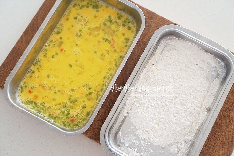 전을 구울 때 알고 있는 공식 레시피로 밀가루 - 계란물 순으로 묻혀주는데요. 밀가루보다 바삭 고소하게 굽기 위해 전분가루가 들어간 튀김가루로 요리했어요. 전분이 들어가 더욱 바삭하고 고소하답니다. 먼저 튀김가루를 묻혀줍니다. 덩어리지지않게 골고루 묻힌 뒤 살살 털어줍니다. 달걀물을 골고루 입혀주어요. 야채도 함께 묻어나도록 해주어요.