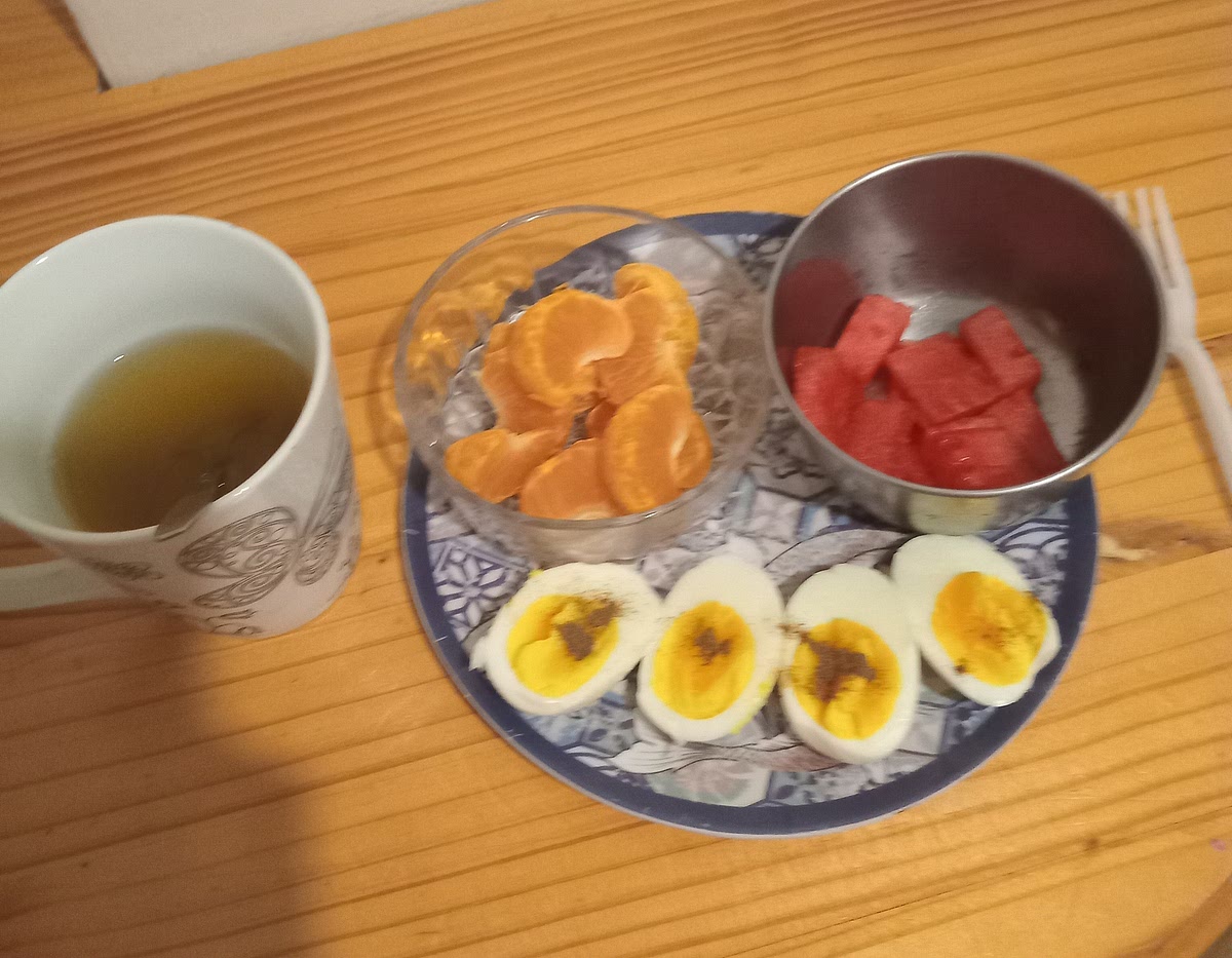 One: get eggs and boiled them two:cut some watermelon and peel orange three:get a cup and green tea bag and put green tea bag in cup and use hot water to pour in the cup