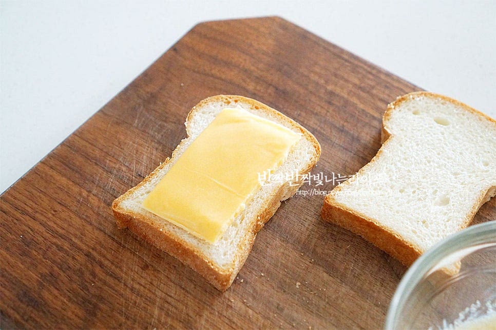 식빵 사이에 슬라이스치즈를 넣어줍니다. 기호에 따라 햄을 같이 넣어도 좋아요. 식빵 위로 달고나 버터 소스를 듬뿍 발라줍니다.