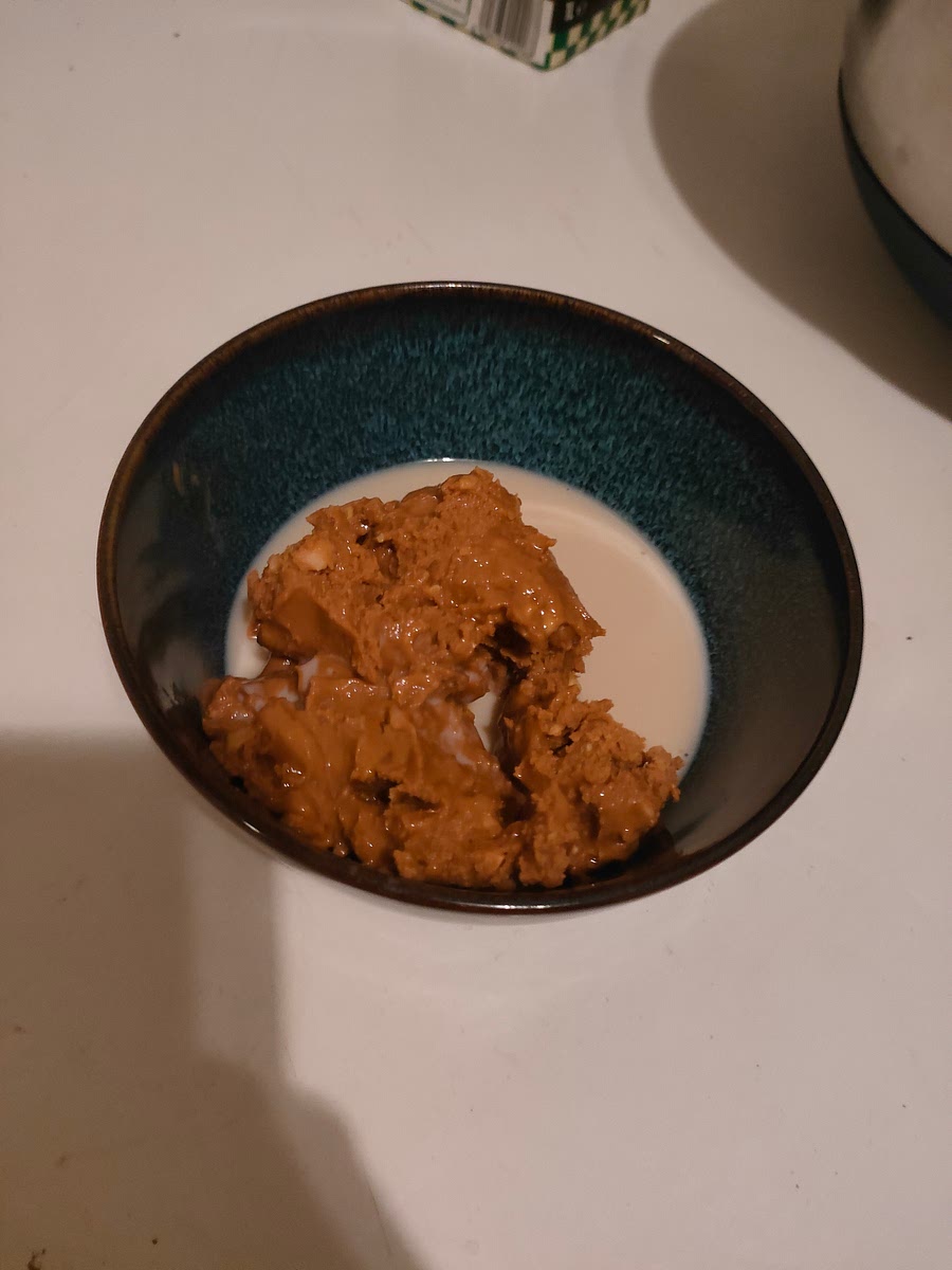 Melt peanut butter in a microwave. Add a bit of milk if it's too tough.
1~2 minutes is usually enough