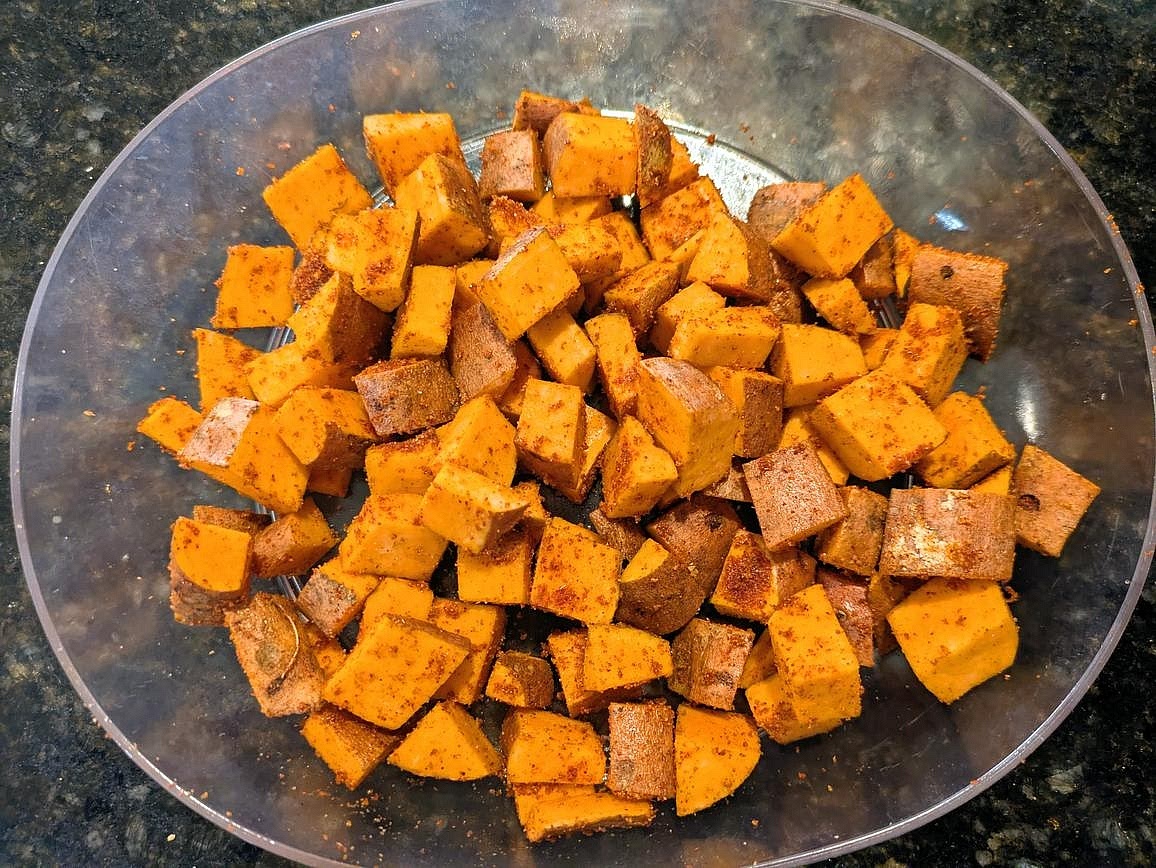 Wash your sweet potato, and cut into a medium dice (with the skin!). Toss with the oil and spices