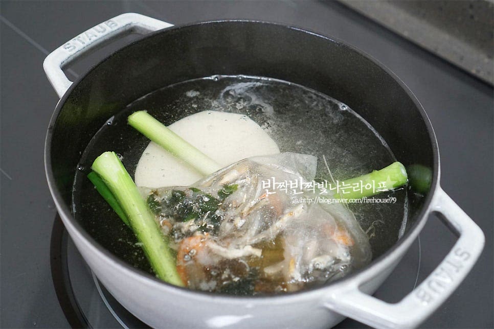 냄비에 물 1L와 육수 팩, 대파와 무를 넣고 20분 정도 끓여 육수를 우려주었어요. 멸치와 다시마, 새우가 들어간 해물다시팩으로 간편하게 육수를 내어주었답니다. 깔끔하게 우린 육수가 끓어오르면 오징어를 넣고 데쳐줍니다. 색이 하얗게 변하고 익으면 오래 데칠 필요 없이 바로 건져내어 줍니다. 오징어는 내장이 제거된 손질된 상태입니다. 크기가 큰 것이라 다리는 제외하고 몸통만 데쳐주었어요. 몸통을 반으로 자른 뒤 한입에 먹기 좋게 채를 썰어줍니다. 다시 육수를 끓인 뒤 콩나물을 넣고 3~5분 정도 끓여요.