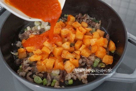 대파가 나른하게 향이 올라오면 썰어둔 깍두기와 김치 국물, 진간장 1 큰 술을 넣어줍니다. 간장은 풍미를 살리기 위해 지글지글 끓여서 섞어주었습니다. 김치의 숙성 정도에 따라 양념재료는 조절해 넣어주면 됩니다. 재료가 어우러지도록 가볍게 섞은 뒤 물 2/3컵을 부어 자박자박하게 끓이듯이 익혀줍니다. 무는 충분하게 익혀주셔야 깊은 맛이 우러납니다. 물의 양은 재료가 익는 상태와 화력에 따라 조절해 주고요. 황설탕 1/3 큰 술, 고추장 2/3 큰 술도 넣어줍니다. 신맛 정도에 따라 설탕으로 새콤함을 잡고 감칠맛을 더합니다. 뚜껑을 덮고 푹 졸이듯이 익혀주면 시원하고 달큰한 깊은 맛이 납니다. 중간중간 저어가며 끓입니다.