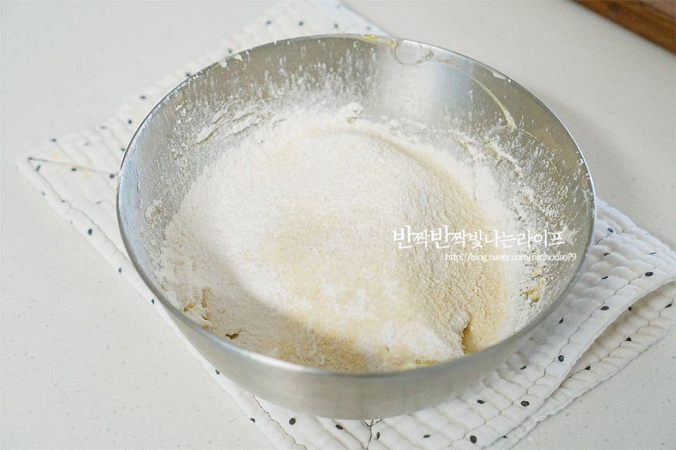 박력분과 아몬드 가루를 체에 내려 주걱을 11자 모양으로 세워 섞어줍니다. 날가루가 보이지 않게 반죽해요. 반죽을 한 덩어리로 뭉쳐 길쭉한 원통 모양으로 만들어 줍니다. 지름 2~3cm 정도로 만들어주었어요. 종이호일로 감싸 냉동실에서 3시간 이상 굳혀줍니다. 저는 밤에 만들어 놓고 다음날 구웠어요. 같은 레시피로 노른자까지 섞고 박력분+코코아 파우더+아몬드 가루 아몬드 슬라이스를 넣고 반죽하여 동일하게 종이호일로 감싸줍니다.