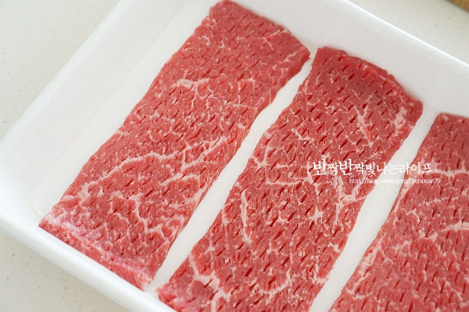 간장양념에 재우기 전에 먼저 잡내를 잡고 부드럽게 만들기 위해 배즙과 양파즙에 재웁니다. 먼저 넓은 볼에 고기를 올려주세요. 배 1/2개를 갈아서 채에 즙만 걸러셔 부어줍니다. 크지 않은 배라 대략 250ml 정도의 배즙이 만들어졌습니다. 간양파 1 큰 술 듬뿍 같이 넣어줍니다. 양파는 향이 있어 너무 많이 넣지 않는 게 재료 본연의 맛을 살릴 수 있습니다. 1차로 1시간 정도 냉장고에 넣고 재워줍니다. 배즙에 먼저 재우면 연육작용이 되어 식감도 부드러워지고 은은한 단맛이 스며들어 나중에 양념도 더 맛있게 어우러집니다.