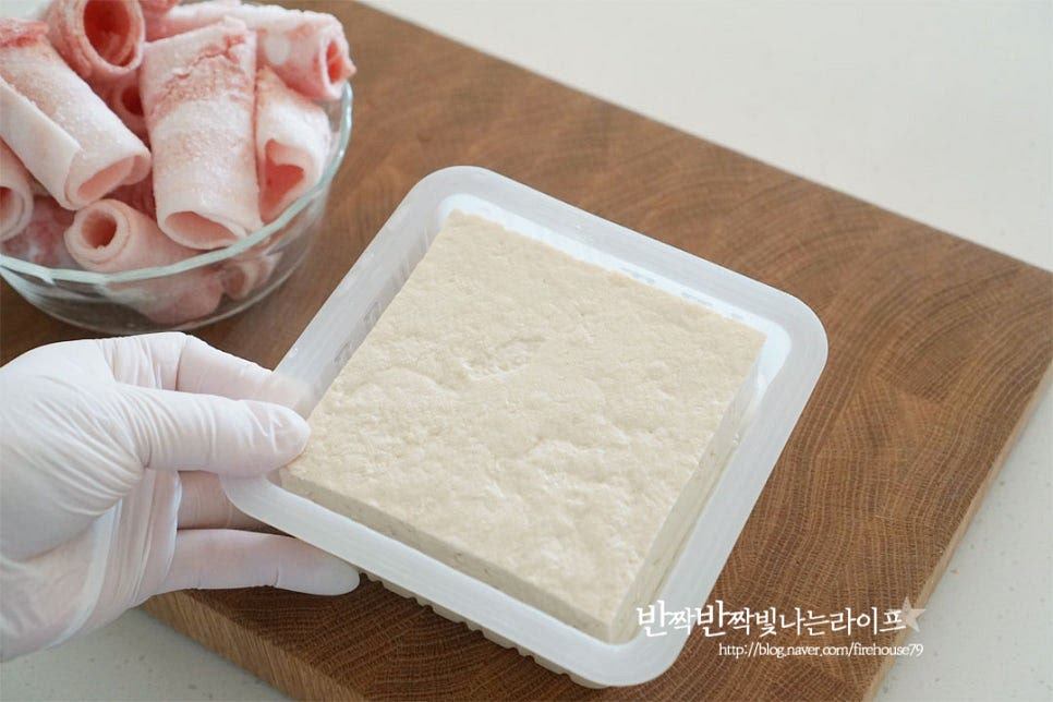 한 모 기준으로 대패는 2줌 넉넉히 준비해 주는데요. 냉동 소분하여 두고 요리하기 간편한 대패삼겹살을 두부조림에 넣어만드는 백종원 레시피는 재료를 먹기 좋게 자르고 양념장에 졸여주기만 하면 어렵지 않아요. 두부조림 레시피를 보면 노릇하게 구워서 만들기도 하는데 오늘 알려드리는 조리법은 그대로 넣고 조림을 만들 것이라 잘 부서지지 않는 단단한 부침용을 준비하여 반으로 잘라 일정한 두께로 썰었습니다. 얇게 썰어 돌돌 말려진 돼지고기는 말린 가운데 사이로 가위를 넣고 반으로 잘라주면 따로 썰지 않고 먹기 좋은 크기로 자르기 좋습니다. 대파와 청양고추는 송송 썰어줍니다. 매콤 칼칼하게 고추를 넣어주었는데 입맛에 맞게 조절하여 주세요.