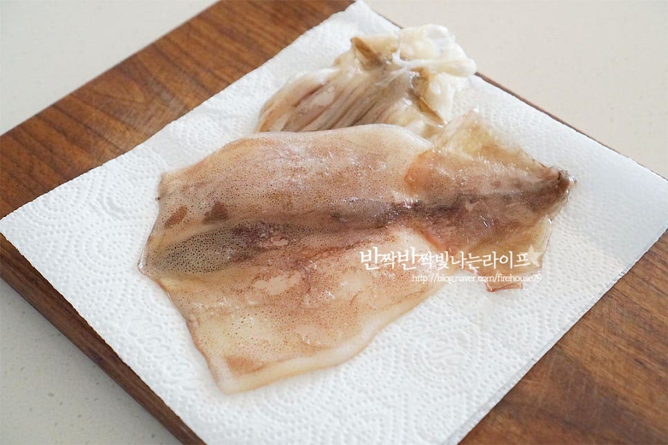 완전히 건조하지 않고 식감을 살려 말린 반건조오징어는 식감이 부드러워 구워서 먹음 특유의 바다 감칠맛과 씹는 맛이 별미인데요. 완전히 건조된 것이 아니라서 보통 집에서 보관하실 땐 냉동 소분해두는데요. 먼저 해동해 준 뒤 흐르는 물에 가볍게 헹구어 물기를 제거해 줍니다. 굽기 전에 먹기 좋도록 가볍게 손질해요. 몸통 뒤쪽을 보면 투명한 뼈가 보이죠. 이 부분은 먹지 못하는 부분이니 먼저 제거해 주어요. 다리 부분에 보이는 눈도 잘라주고 (좋아하신다면 구워서 드셔도 됩니다.) 다듬어 줍니다. 몸통은 그대로 굽는 것보다 고르게 익을 수 있도록 가위로 양옆 칼집을 넣어줍니다. 칼집을 넣어 구워주면 잘 구워지기도 하고 속까지 탱글 하게 익고 먹기 좋게 찢어먹기도 좋아요~
