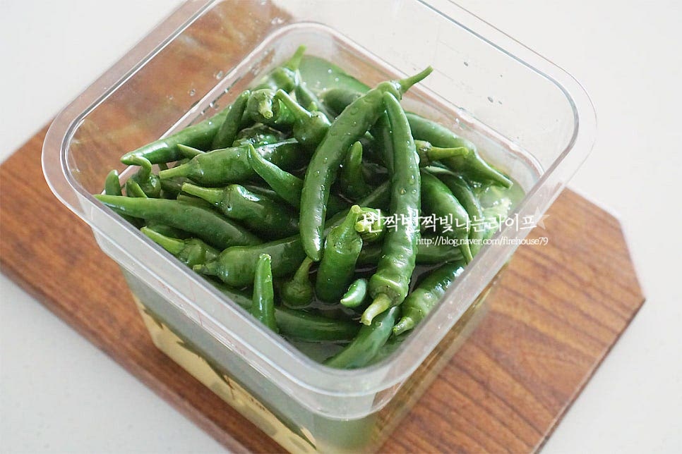 고추가 잠기게 부어줍니다. 잘 숙성될 수 있도록 누름돌이나 용기로 눌러주어 청양고추가 위로 뜨지 않고 물에 잠길 수 있도록 해줍니다. 저는 밀폐용기에 딱 맞는 다른 밀폐용기를 열탕소독하여 위에 끼워 눌러주었더니 딱 맞게 삭히기 좋았어요. 통풍이 잘 되는 서늘한 곳에 두고 3~4주 정도 숙성하여 주면 그 뒤로 드시면 됩니다. 추운 계절에는 밖에 두어도 되지만 아니라면 냉장보관해주시고요~ 일주일 이상 지나면 점점 색이 노랗게 삭혀지는게 보여요. 양념에 무치거나 다져서 반찬을 만들어도 좋고 겨울철 김치 담글 때 넣으면 딱이라 청양고추 끝물에 미리 만들어 두어요. 영상도 같이 담았어요. 소금물 비율만 잘 맞추면 골마지 없이 맛있게 삭힐 수 있어요. 소금은 너무 작게 넣어도 오히려 잘 만들어지지 않으니 물의 양 10% 이상은 맞추어 소금을 넣어주세요. 고추삭히는법 골마지없이 맛있게 만들어 드세요^^ 끄읕 !