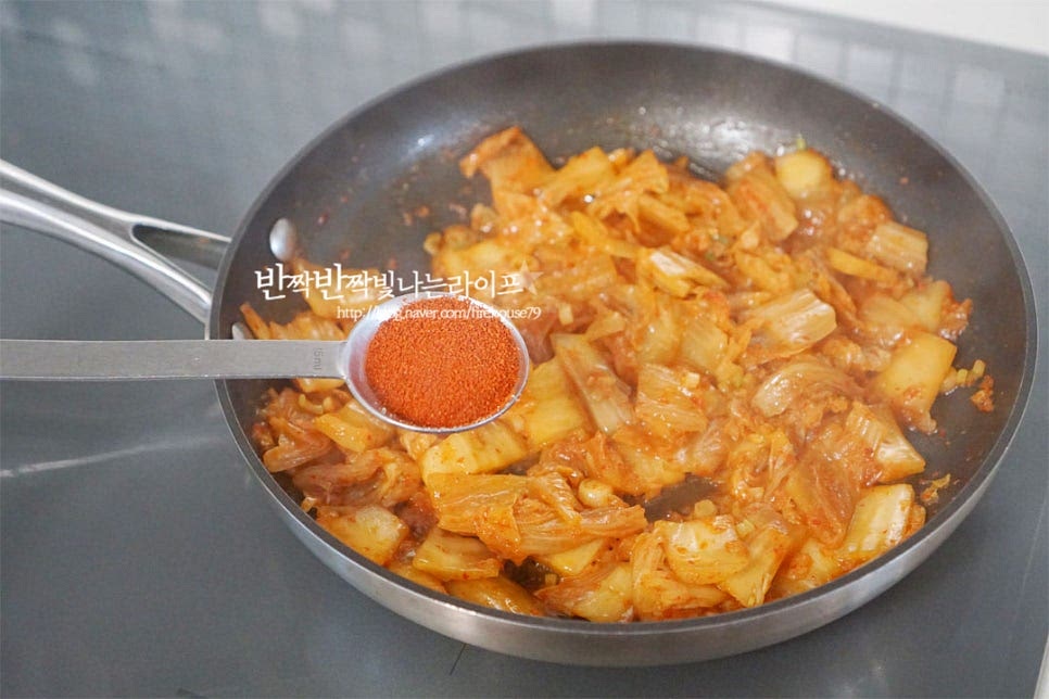 고춧가루 1 큰 술, 다진 마늘 1/2 큰 술 진간장 1 작은 술 넣어줍니다. 몇 가지 양념재료를 넣고 매콤함과 향미를 더해주는데요. 간장은 향을 내어주기 위해 넣어주었는데 간에 따라 양은 가감해 주면 됩니다. 김치가 나른해지도록 중약불에서 충분하게 볶아 재료의 깊은 맛이 나올 수 있도록 해줍니다. 대략 10~12분 색이 진해지도록 볶아주어요.