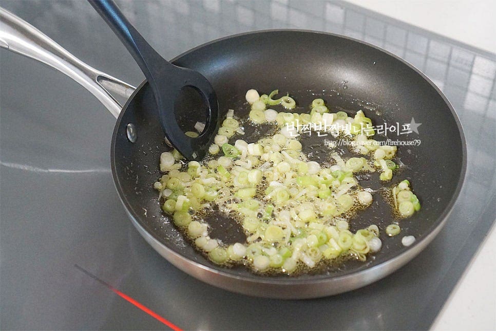 달군 팬에 들기름 1 큰 술, 식용유 1 큰 술을 넣고 대파를 먼저 볶아 향을 내어줍니다. 타지 않게 중약 불로 불조절을 해주고, 대파가 나른하고 향긋해지도록 볶아주면 됩니다. 파의 향이 올라오면 썰어둔 배추김치를 넣고 가볍게 섞어줍니다. 신맛을 잡아주고 감칠맛을 살리기 위해 황설탕 2/3 큰 술을 넣어줍니다. 새콤한 정도에 따라 설탕을 조절해 주어야 너무 달지 않고 새콤달콤 맛이 좋습니다. 설탕입자가 녹아 어우러지도록 볶아줍니다.