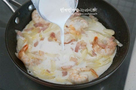 재료가 노릇하게 볶아지면 우유 250~300ml를 부어줍니다. 우유만 넣어도 되지만 생크림과 섞어 넣으면 조금 더 진하고 꾸덕꾸덕하게 만들 수 있어요. 농도에 따라 양은 조절해 주세요. 끓어오르기 시작하면 분말스프 1/2개, 건더기스프를 넣어줍니다. 간에 따라 짜지 않게 양을 조절해 주세요. 매콤함을 더하고 싶다면 고춧가루나 청양고추를 넣어주고요. 재료가 어우러지도록 섞어 끓여줍니다. 소스가 만들어지면 삶은 라면을 넣어줍니다. 우유라면의 녹진함을 살려주기 위해 슬라이스 체다치즈 1장도 같이 넣고 섞어줍니다. 면이 약간 덜 익은 상태로 국물 자작하게 소스와 어우러지면서 간이 스며들고 농도도 더 진해집니다. 입맛에 따라 치즈를 갈아 넣어도 좋고 후추 약간 뿌려주셔도 됩니다. 완성되면 불을 끄고 면을 돌돌 말아서 접시에 담아 먹음직스럽게 마무리해요.