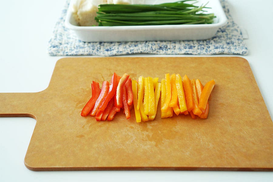 채소를 채 썰어주세요. 빨강, 노랑, 주황 파프리카는 꼭지 부분과 씨를 제거하고 얇게 채 썰어 주었어요. 두껍게 써는 것보다 얇은 게 식감도 아삭하고 돌돌 말기 좋아요. 팽이버섯은 밑동을 잘라내었어요. 부추도 먹기 좋게 잘라주었어요. 야채 길이는 고기의 너비에 맞추어 채 썰어주시면 되어요.