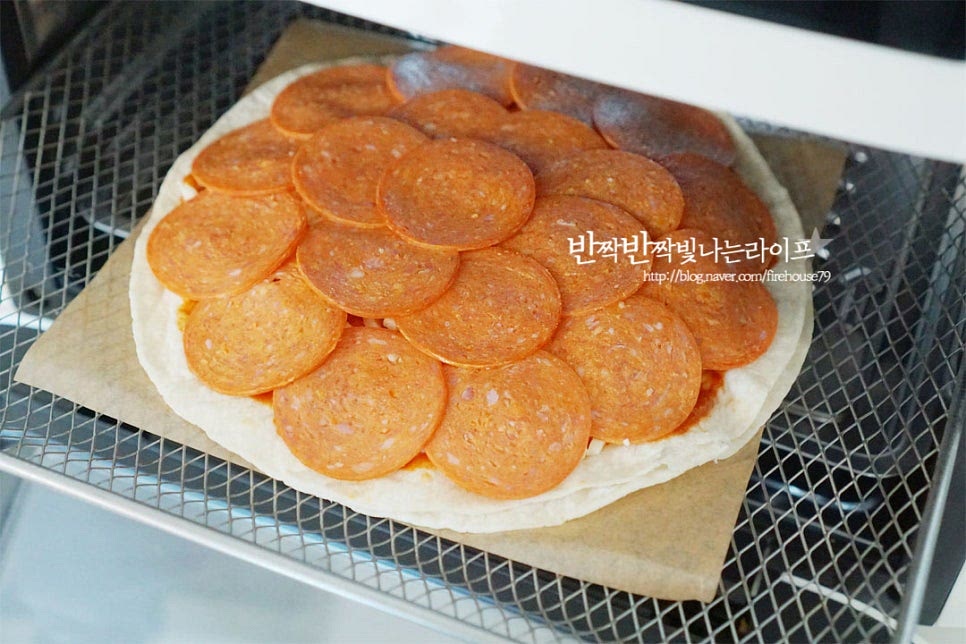 집에서 피자를 구울 때는 에어프라이어, 오븐 프라이팬, 전자레인지를 활용할 수 있는데요. 바삭한 식감을 살려주기 위해 에어프라이어로 구워주었습니다. 에어프라이어 또띠아피자는 180도 8~10분 사이로 구워줍니다. 기기의 사양에 따라 온도와 시간은 조절해 주고 중간에 구워지는 것을 확인해가며 구우면 됩니다. 구워지면서 지글지글 햄이 익어요. 바삭하고 고소한 냄새가 가득하답니다. 맛깔나게 구워지면 뜨거울 때 바로 꺼내서 먹음 파는 것 못지않게 맛나요. 얇은 도우를 두 장 겹쳐서 만들어 바삭바삭하고 고소한 식감도 맛있고, 사이로 쭉 늘어나는 치즈의 눅진함과 페퍼로니가 짭조름한 감칠맛으로 가득 채워준답니다. 영상도 같이 담았어요. 또띠아 위에 토마토소스를 바른 뒤 치즈와 햄을 올려 만드는 초간단 레시피로 집에서도 간단하면서 근사하게 맛볼 수 있어요. 또띠아 피자 만들기 짭조름한 페퍼로니 토핑을 올려 색다르고 맛있게 요리해드세요^^ 끄읕 !